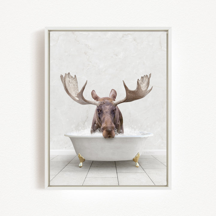 A moose with large antlers is sitting in a white bathtub filled with water, creating a whimsical and humorous scene.
