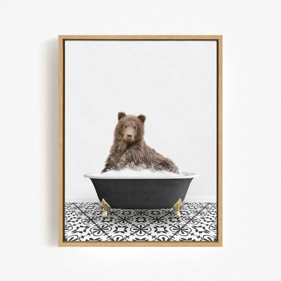 A brown bear sitting in a black bathtub filled with bubbles, surrounded by a black and white patterned floor.
