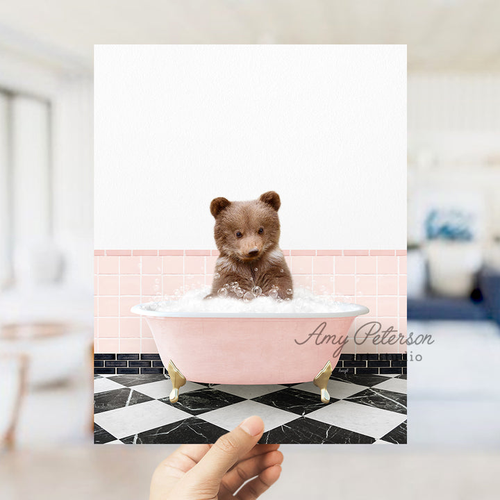 a person holding up a card with a picture of a teddy bear in a bath