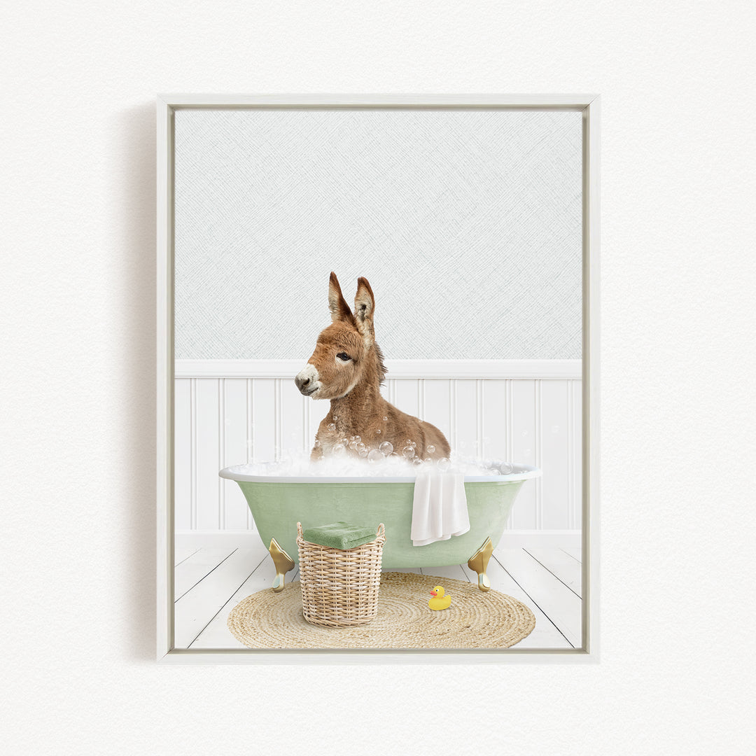 A donkey is sitting in a green bathtub filled with bubbles, surrounded by a basket of toys and a yellow rubber duck.
