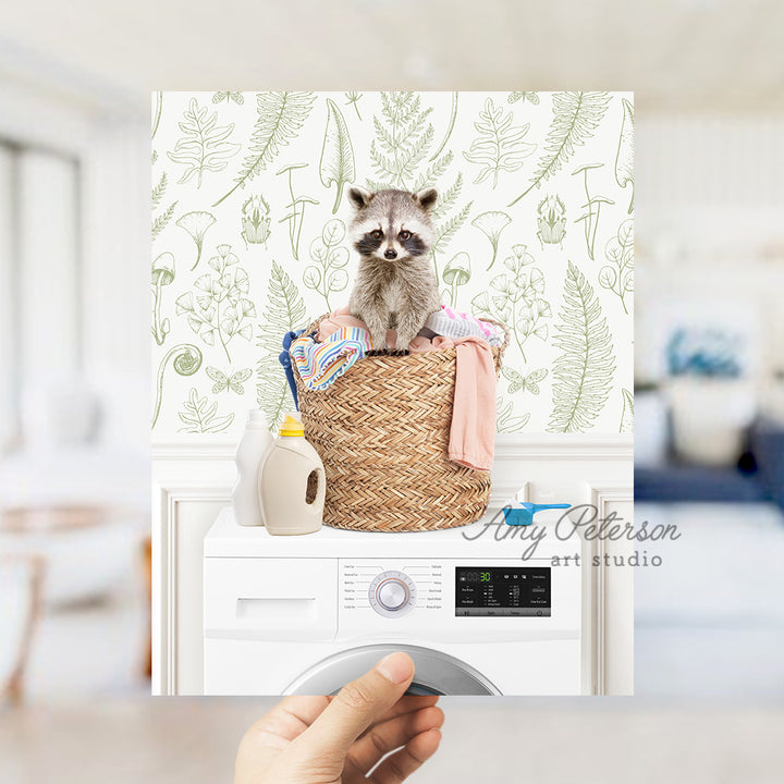 a person holding a photo of a raccoon in a laundry basket