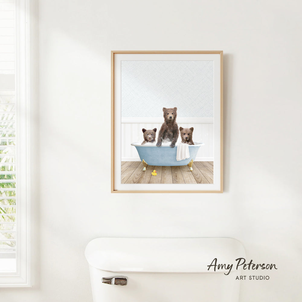 A framed image of three bears sitting in a bathtub, with one bear sitting on the edge of the tub and the other two bears sitting inside the tub.