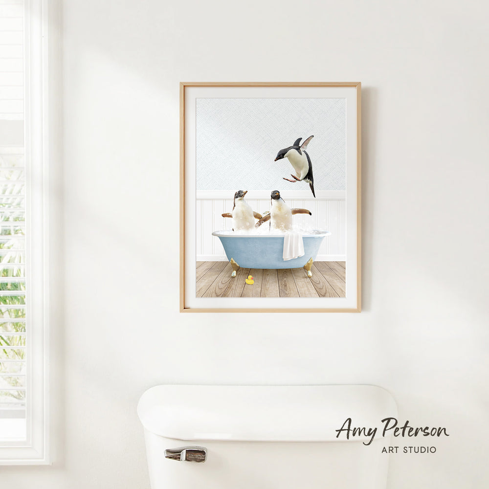 A framed image of two penguins sitting in a bathtub, with one penguin standing on the edge of the tub.