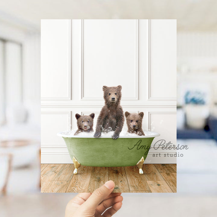 a hand holding a card with three bears in a bathtub