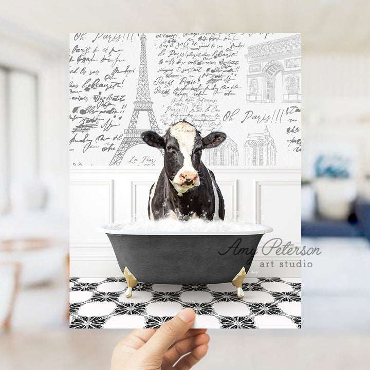 a person holding up a card with a picture of a cow in a bathtub