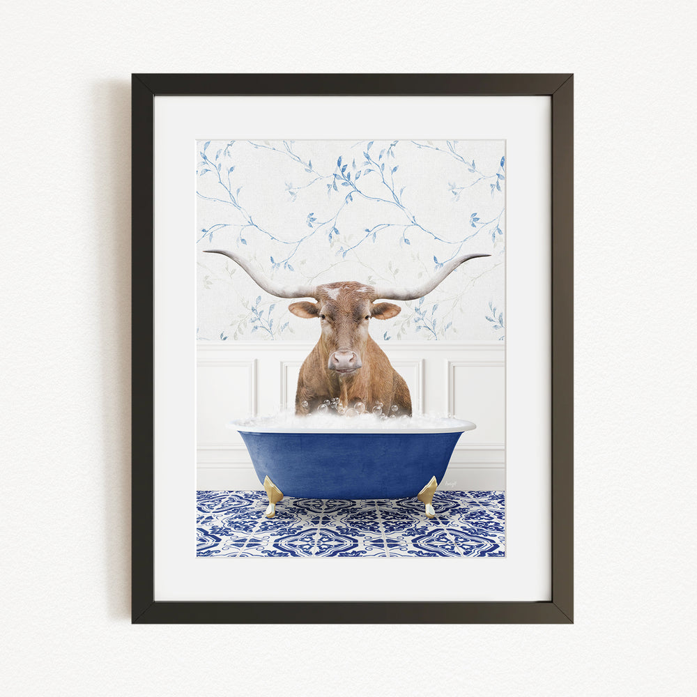 A brown steer with large horns is sitting in a blue bathtub filled with water, surrounded by a blue and white patterned tile floor.