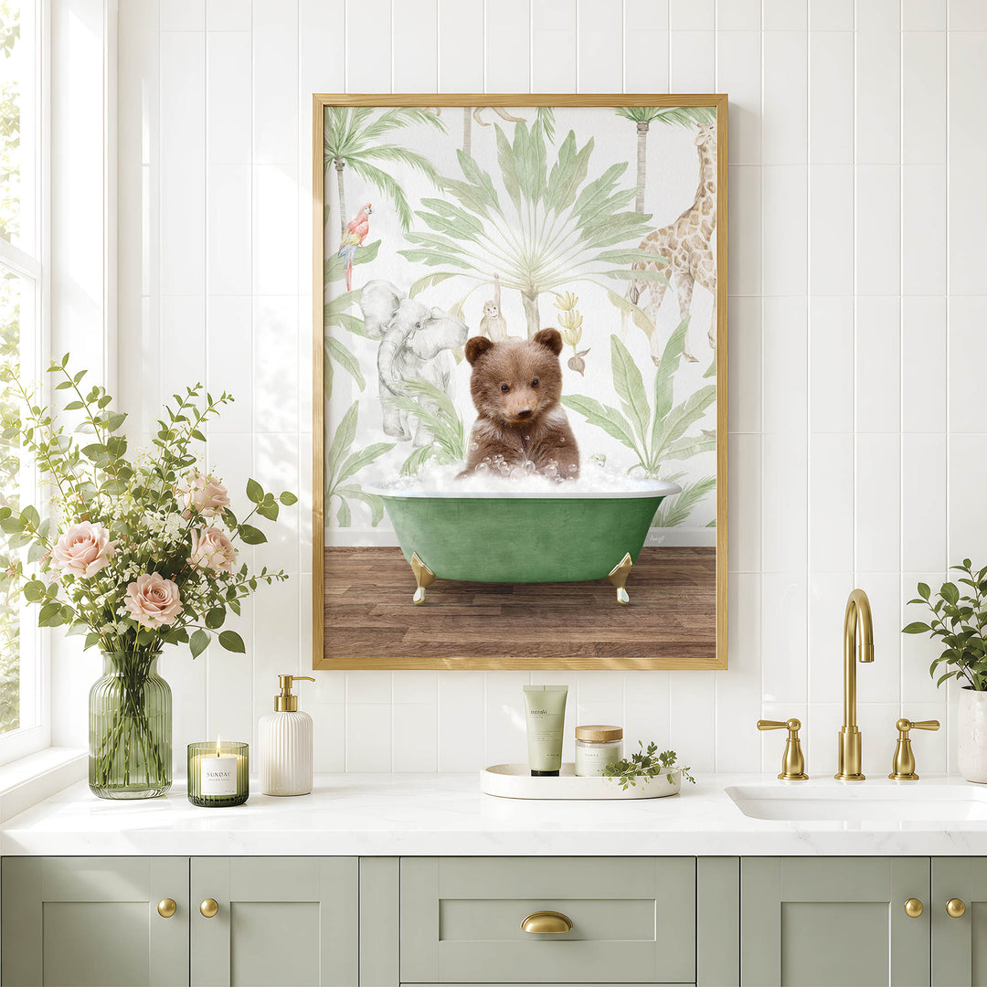 A framed image of a baby bear sitting in a bathtub, surrounded by tropical foliage, is displayed on a wall above a bathroom counter with various toiletries and decor.