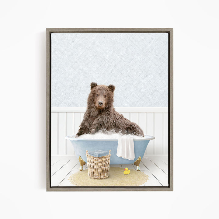 A brown bear sitting in a blue bathtub filled with bubbles, surrounded by rubber ducks and a basket.