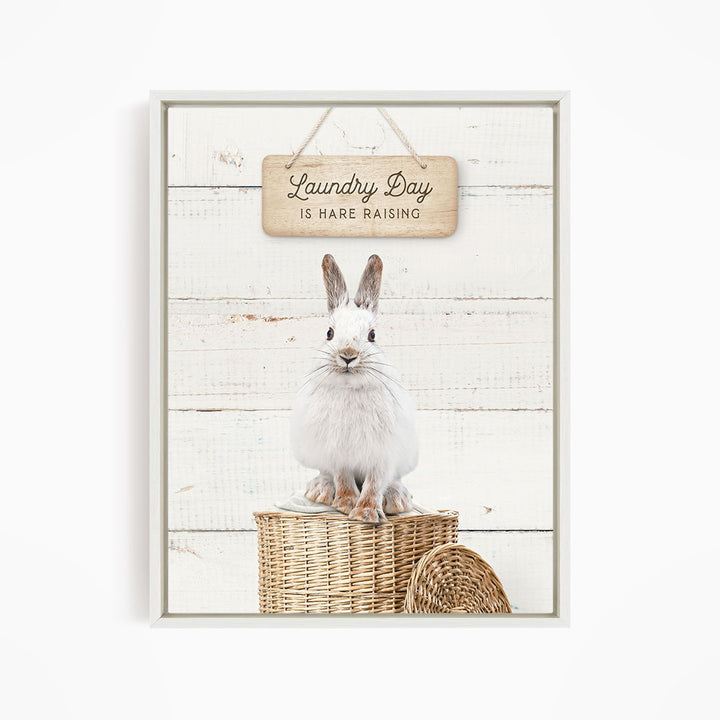 A white rabbit sitting on a wicker basket, with a wooden sign above that says "Laundry Day is Rare Raising".