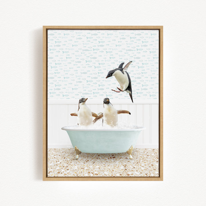 A framed image depicting two penguins sitting in a bathtub, with one penguin jumping out of the tub.