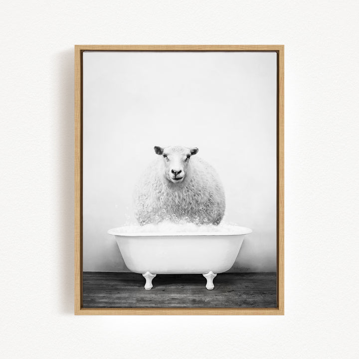 A fluffy white sheep sits in a white bathtub filled with bubbles, looking directly at the camera.