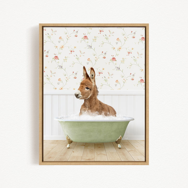 A donkey is sitting in a green bathtub filled with water, surrounded by a floral wallpaper.
