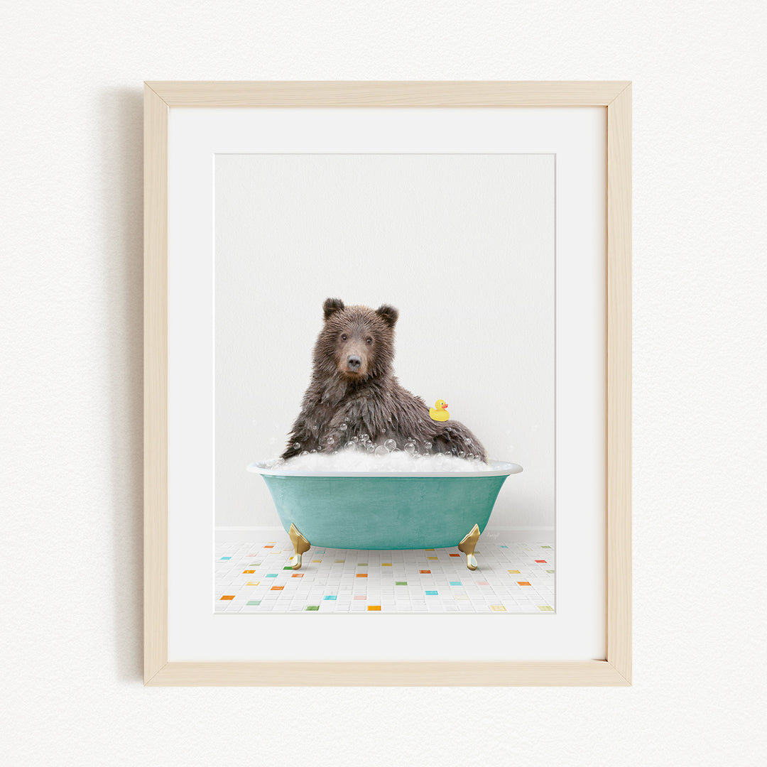 A brown bear sitting in a blue bathtub filled with bubbles, surrounded by small rubber ducks.