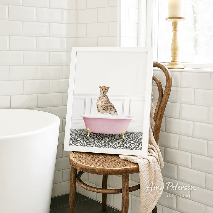 A cheetah sitting in a pink bathtub, surrounded by a patterned rug, in a bathroom setting.