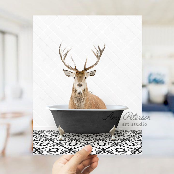 a hand holding up a card with a picture of a deer in a bathtub