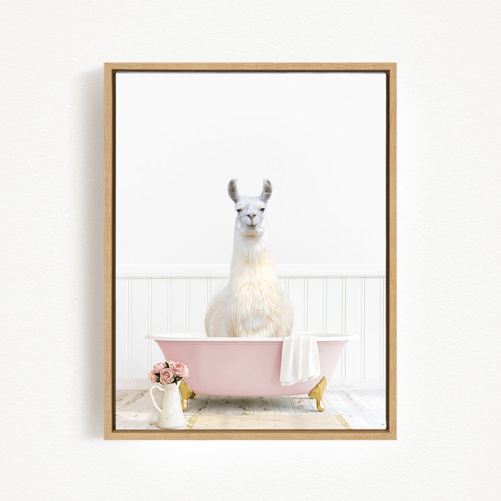A white llama sitting in a pink bathtub, with a vase of flowers and a white pitcher nearby, against a white background.