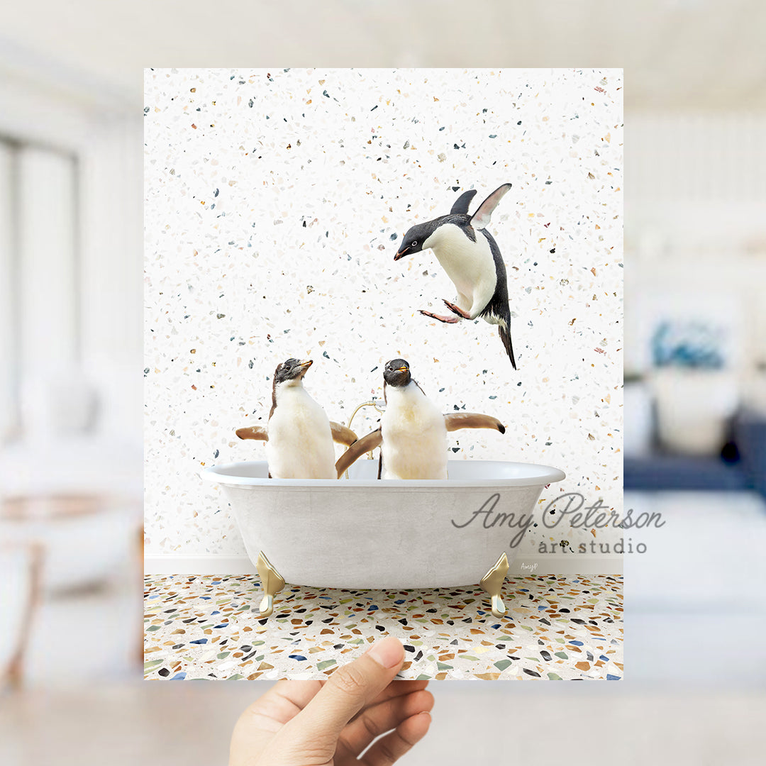 a hand holding a card with three penguins in a bathtub