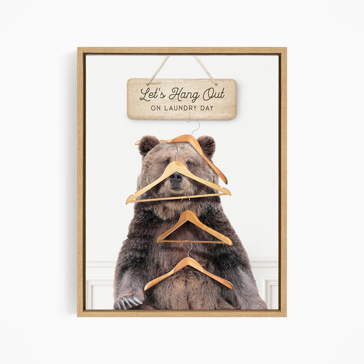 A framed image of a bear holding a sign that says "Let's Hang Out on laundry day".