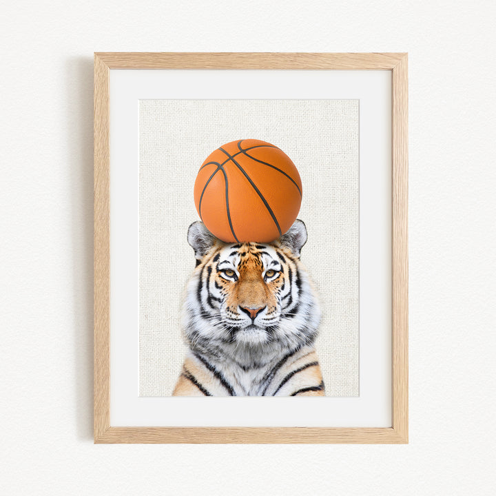 A tiger is sitting on a basketball, with the basketball positioned on top of its head.