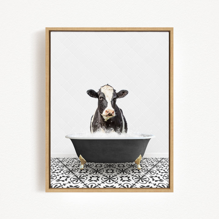 A black and white cow is sitting in a black bathtub filled with water, creating a whimsical and humorous scene.