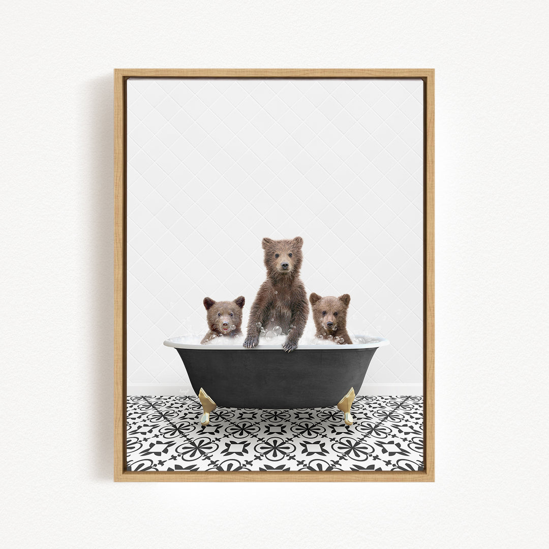A framed image depicting three bears sitting in a bathtub, with one bear standing and the other two sitting.