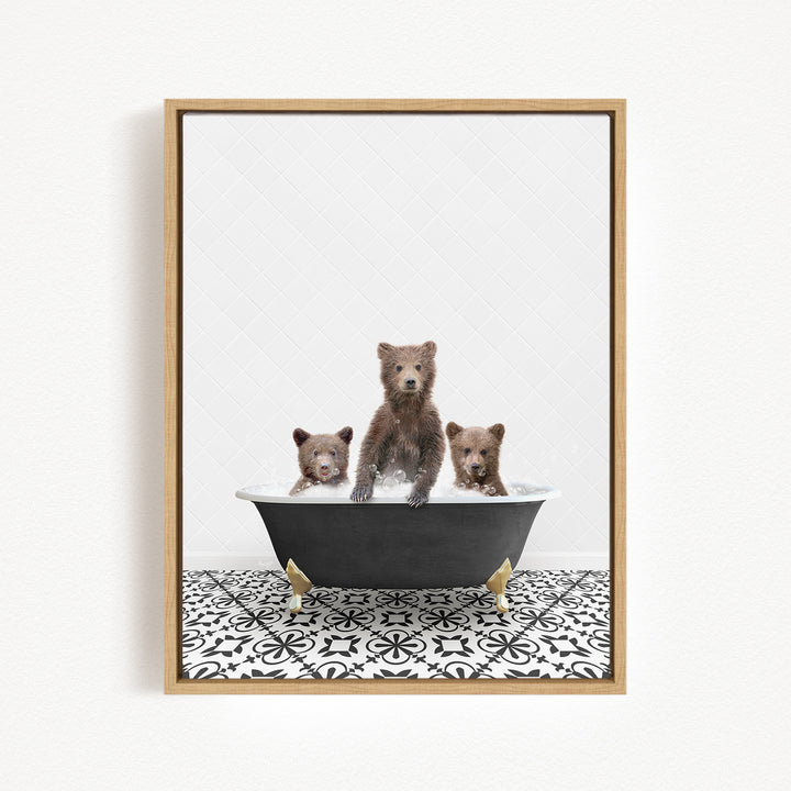 A framed image depicting three bears sitting in a bathtub, with one bear standing and the other two sitting.