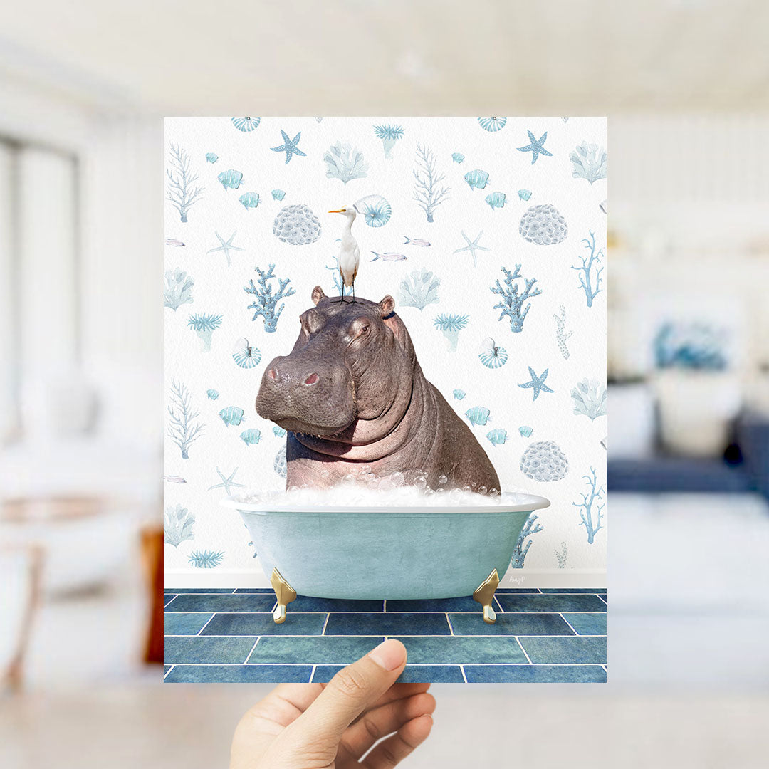 A hand holds up a collage of images featuring a hippopotamus sitting in a bathtub, with a bird perched on its head.