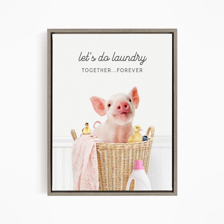 A cute pig sitting in a wicker basket filled with toys, accompanied by the text "let's do laundry together forever".