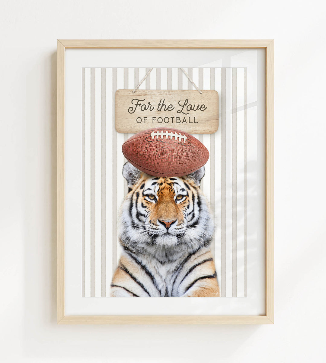 A framed image of a tiger with a football on its head, accompanied by a wooden sign that reads "For the Love of Football".