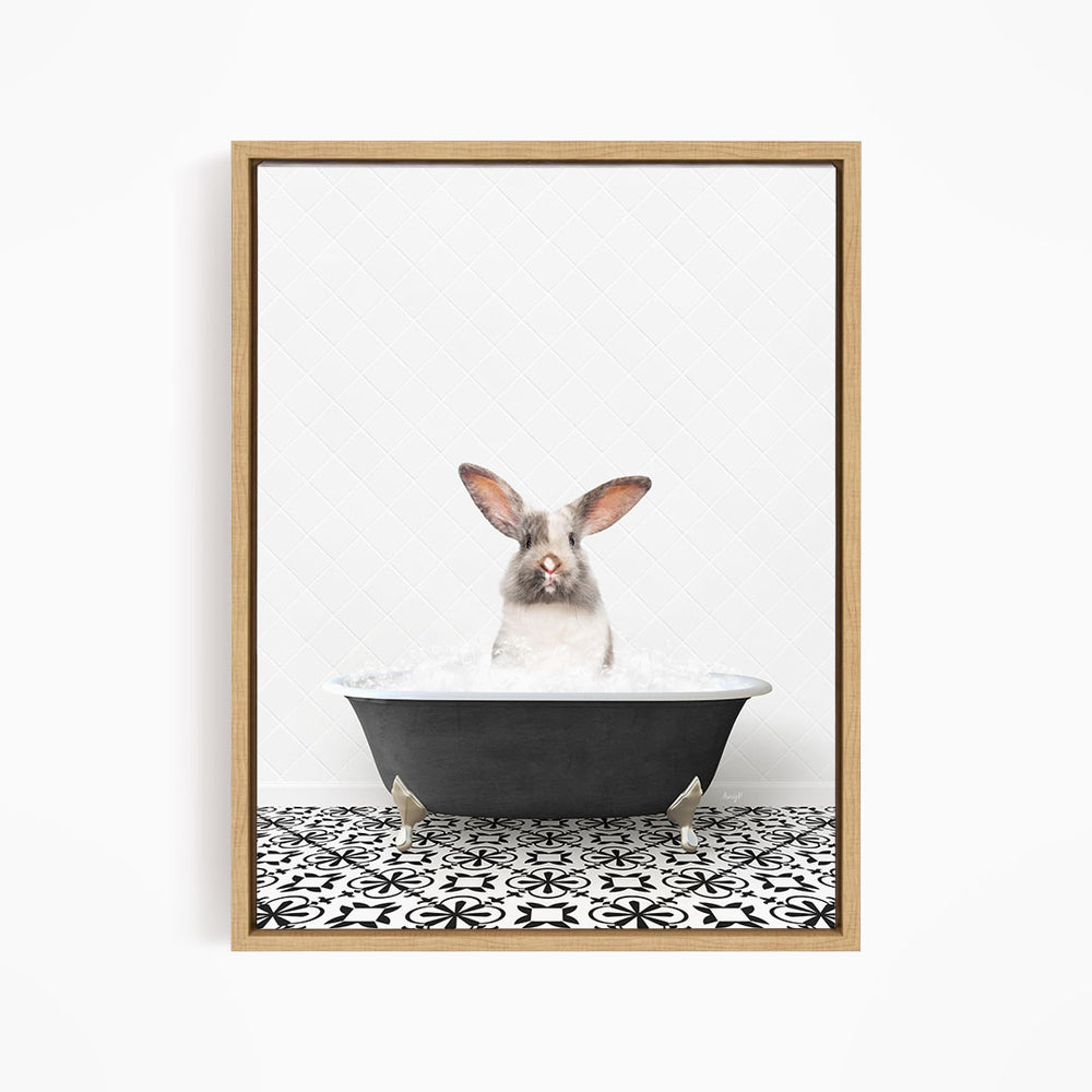 A white rabbit with brown ears is sitting in a black bathtub filled with water, looking directly at the camera.
