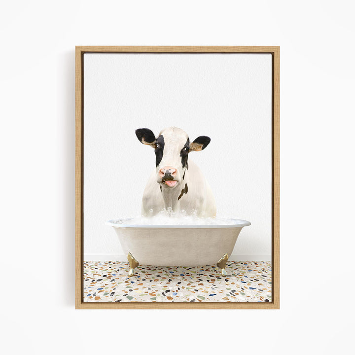 A black and white cow is sitting in a white bathtub filled with water, creating a whimsical and humorous scene.