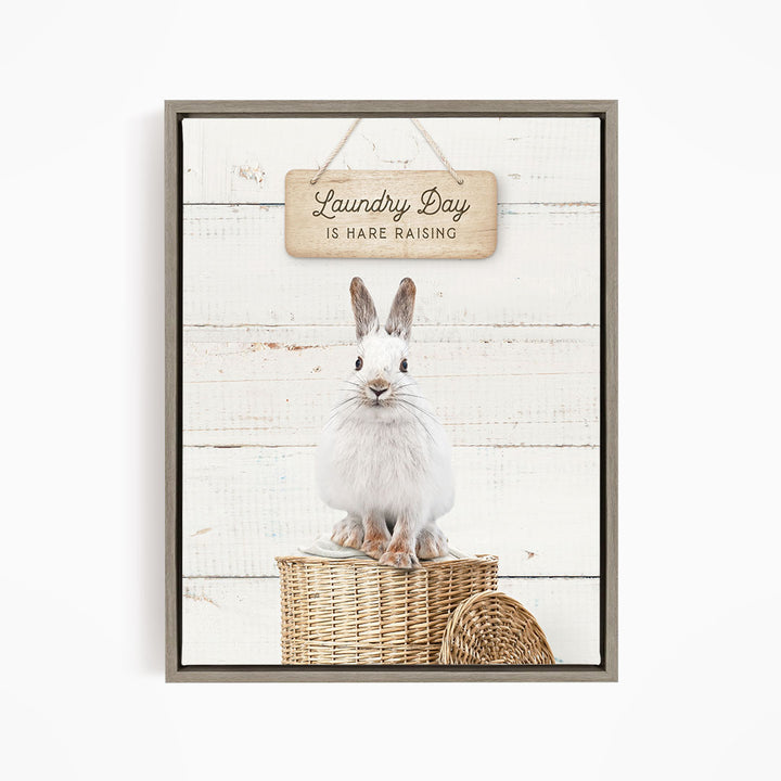 A white rabbit sitting in a wicker basket, with a wooden sign above that says "Laundry Day is Hare Raising".