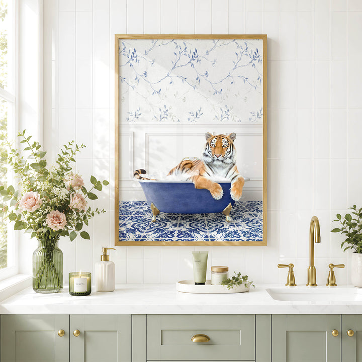 A framed image of a tiger sitting in a blue bathtub, surrounded by flowers and a decorative vase, with a white and blue floral pattern on the wall behind it.