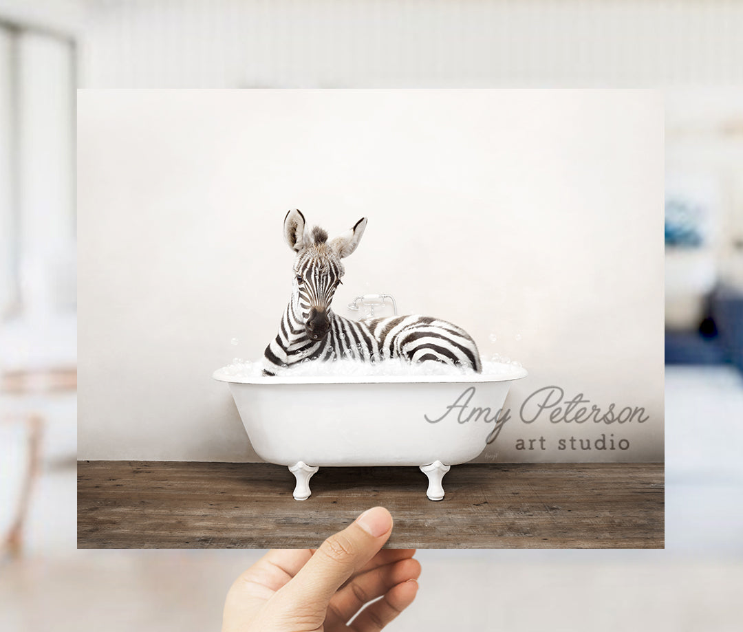 a hand holding up a card with a zebra in a bathtub