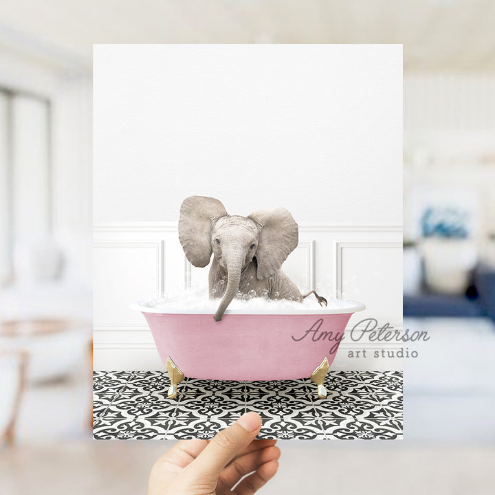 a person holding up a card with an elephant in a bathtub