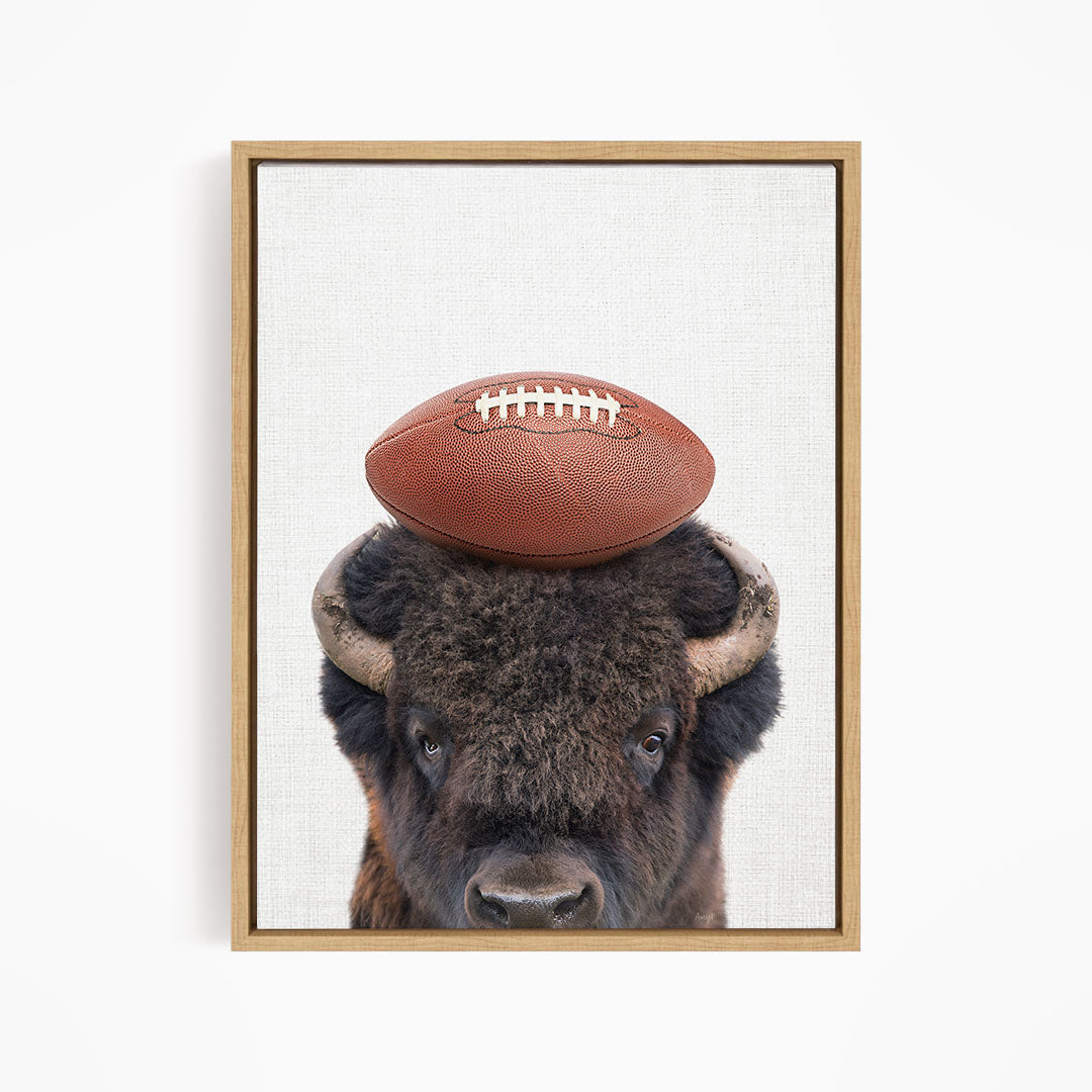 A buffalo with a football resting on its head.
