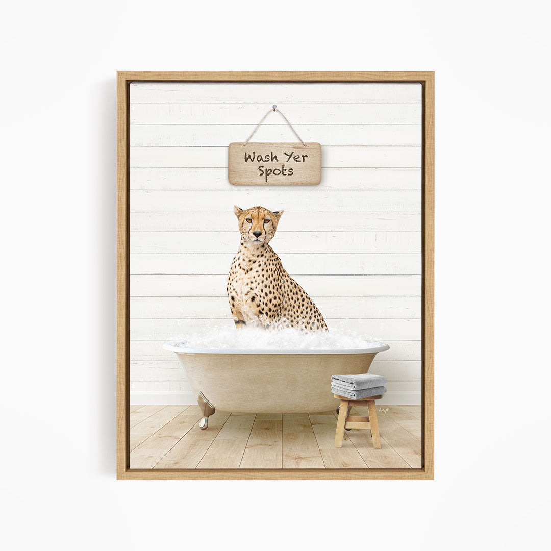 A cheetah sitting in a bathtub filled with water, with a sign above that says "Wash Yer Spots".