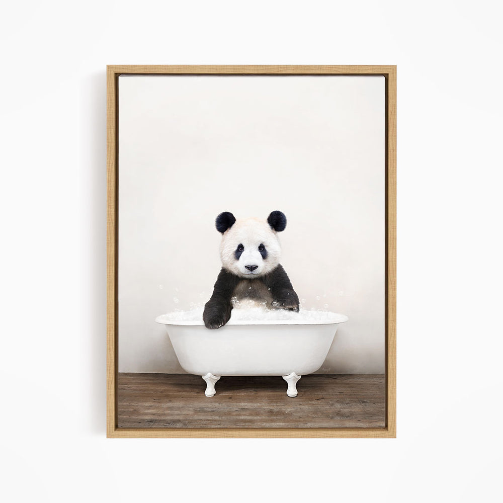 A panda bear sitting in a white bathtub filled with bubbles, looking directly at the camera.