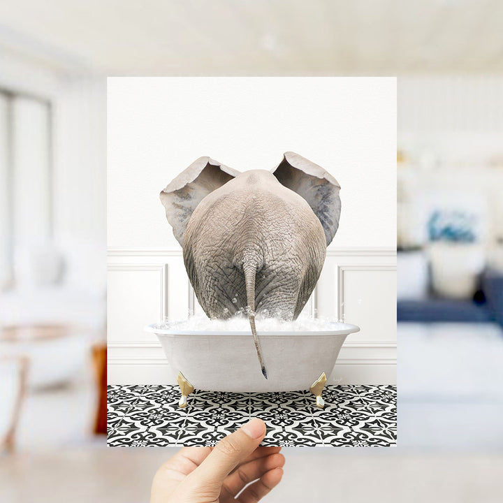 A gray elephant is sitting in a white bathtub filled with water, with its trunk submerged in the water.