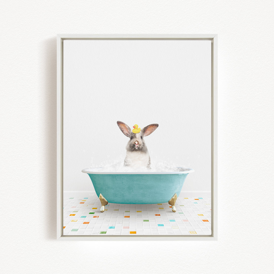 A gray and white rabbit sitting in a blue bathtub filled with water, wearing a yellow hat.