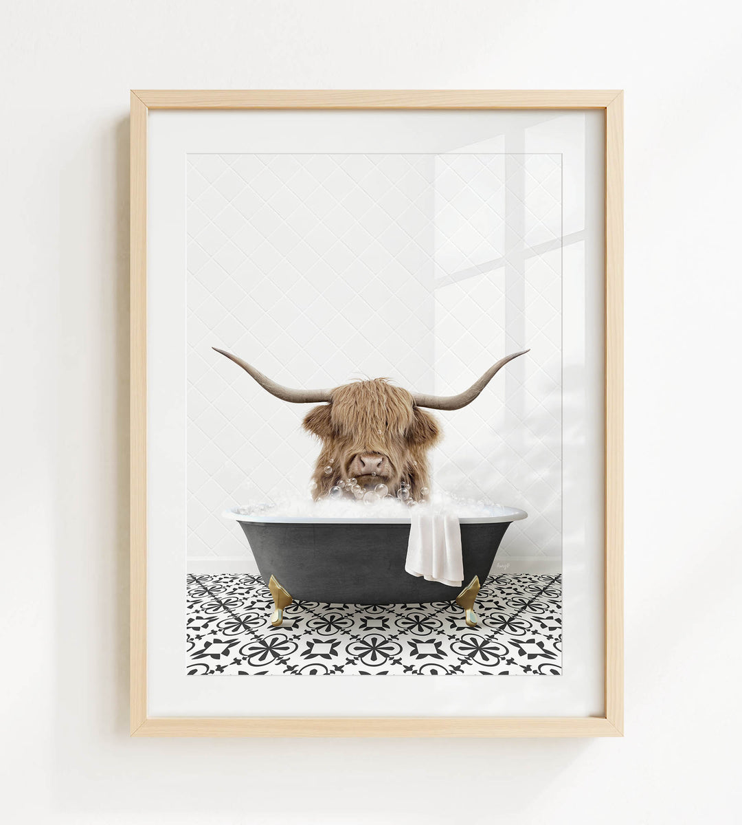 A framed image depicting a Highland cow with long horns sitting in a bathtub filled with water and bubbles.