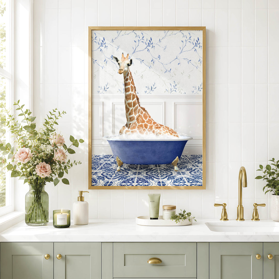 a giraffe sitting in a blue bathtub, surrounded by flowers and a framed picture on a white tiled wall.