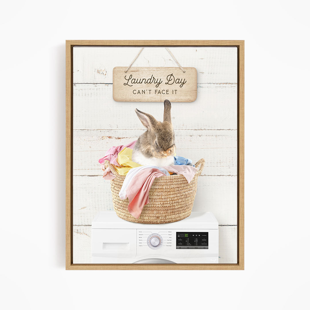 A cute rabbit sitting in a woven laundry basket, with a sign above that says "Laundry Day Can't Face It".