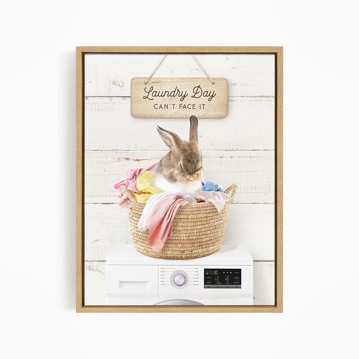 A cute rabbit sitting in a woven laundry basket, with a sign above that says "Laundry Day Can't Face It".