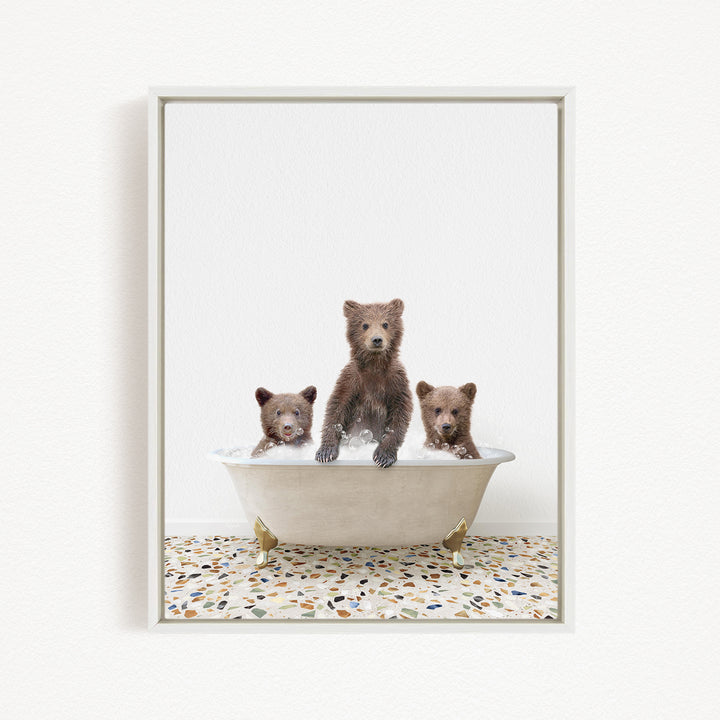 A framed image showing three brown bears sitting in a white bathtub, with one bear standing in the center and the other two sitting around it.
