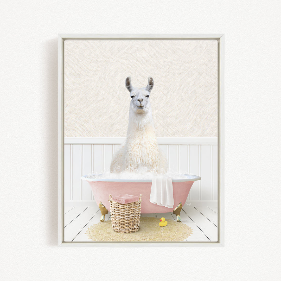 A white llama sitting in a pink bathtub filled with bubbles, surrounded by a yellow rubber duck and a wicker basket.