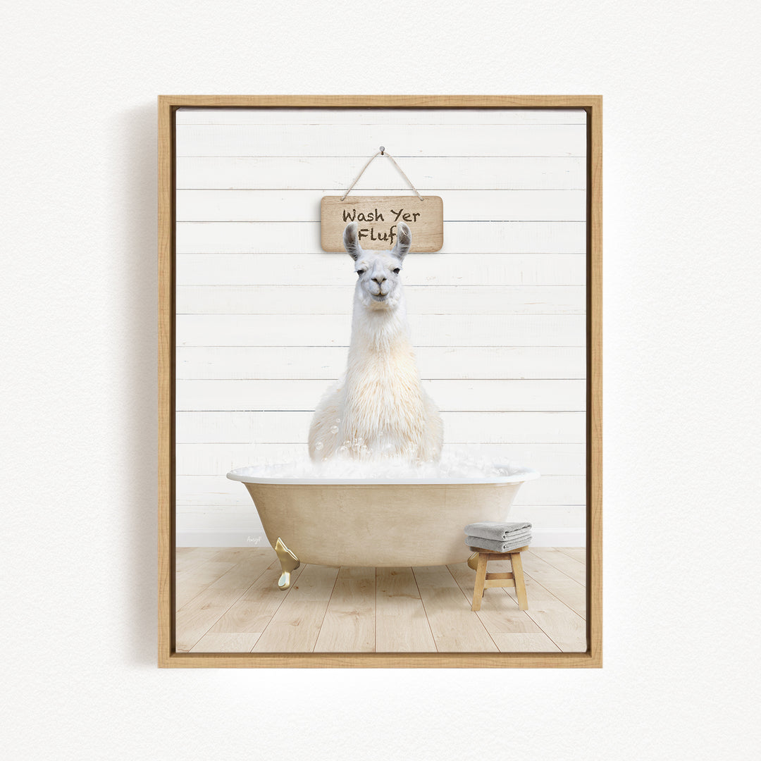 A white llama sitting in a bathtub, with a wooden sign above it that says "Wash Yer Fluff".