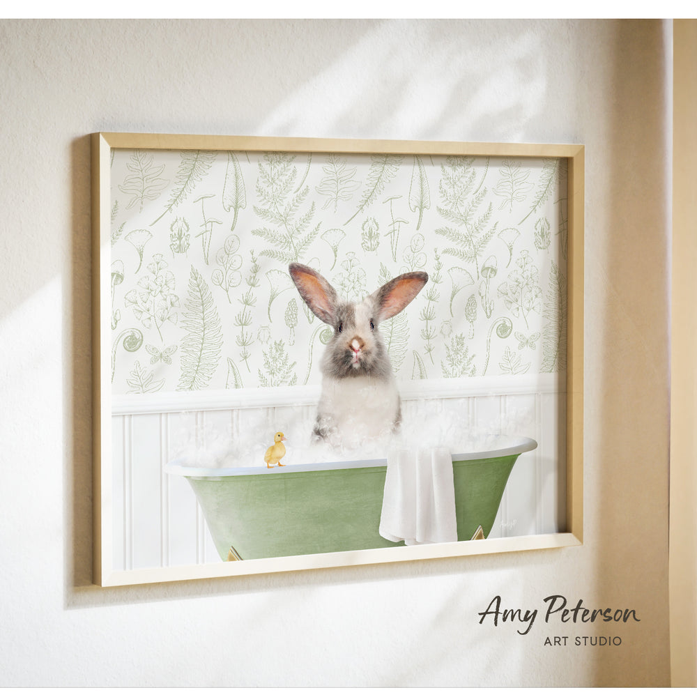 A framed image of a rabbit sitting in a green bathtub, with a yellow duck sitting on the edge of the tub.