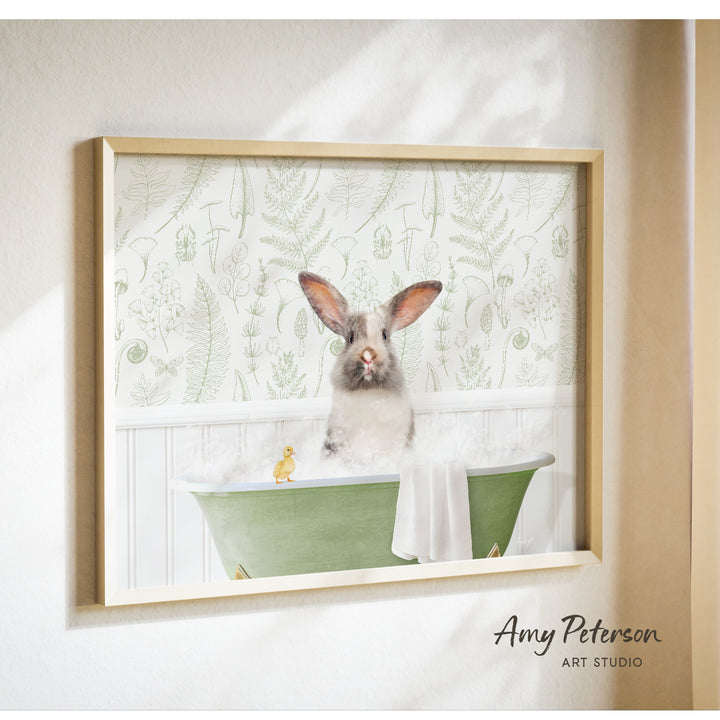 A framed image of a rabbit sitting in a green bathtub, with a yellow duck sitting on the edge of the tub.
