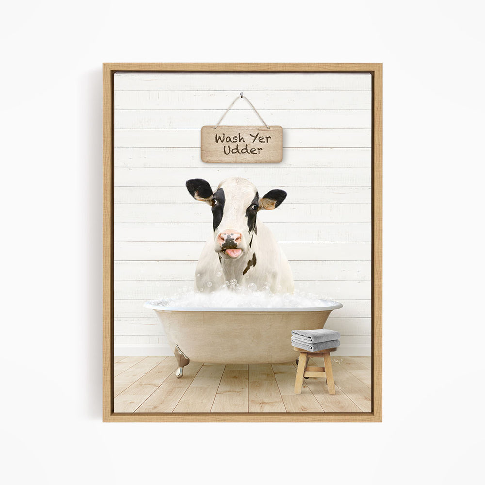 A black and white cow is sitting in a bathtub filled with water, with a sign above it that says "Wash Yer Odder".